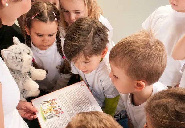 Kinder lesen gemeinsam die Geschichte der kleinen Katze Gimmli
